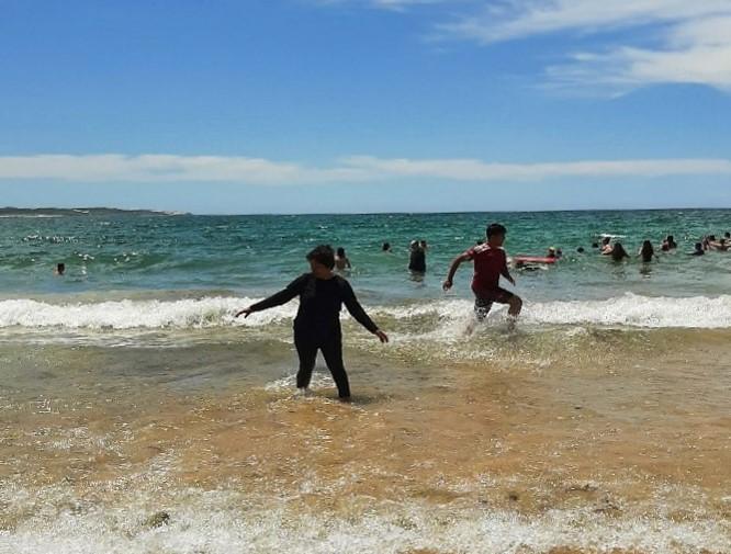 a group of kids playing in the water at Cronulla Beach