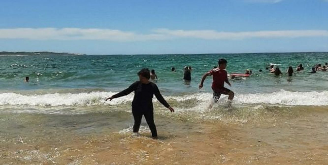 a group of kids playing in the water at Cronulla Beach